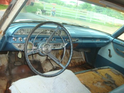 1962 Ford Galaxie - Interior view of a vintage car, showing the dashboard, steering wheel, and worn seating.