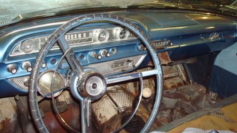 1962 Ford Galaxie - The dashboard and interior of an older vehicle, showing the steering wheel, gauges, and radio.