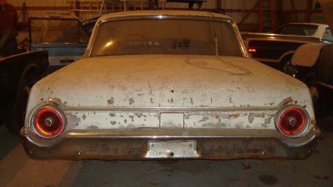 1962 Ford Galaxie - Rear view of a 1962 Ford Galaxie, showing its distinctive taillights and chrome trim. The car appears to be in storage.