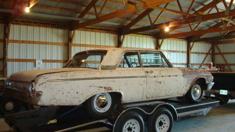 1962 Ford Galaxie - This weathered 1961 Ford Galaxie is loaded onto a trailer, revealing its aged condition and distinctive body style.