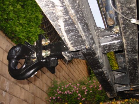 1985 Ford Bronco - Close-up view of a heavy-duty tow hitch receiver and hook mounted on a vehicle's frame.