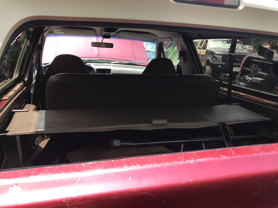 Interior view of a red SUV, looking forward. Another SUV is visible outside