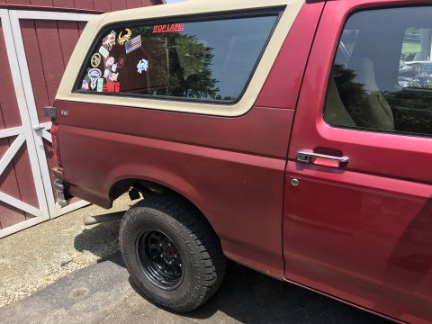 1994 Ford Bronco - Side view of a red 1994 Ford Bronco, parked next to a red barn.