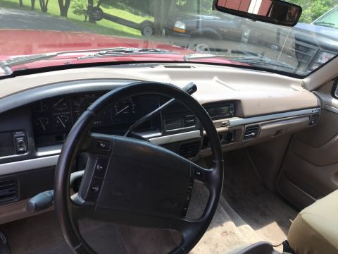 1994 Ford Bronco - Interior view of a red Ford Bronco, with a trailer visible through the windshield.