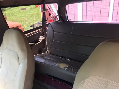 1994 Ford Bronco - The interior of a 1994 Ford Bronco, rear seating and a view through the side window.