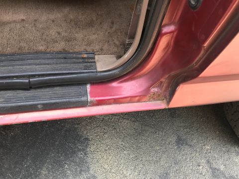 1994 Ford Bronco - The door sill of a vehicle shows signs of wear and rust, indicating potential maintenance needs.