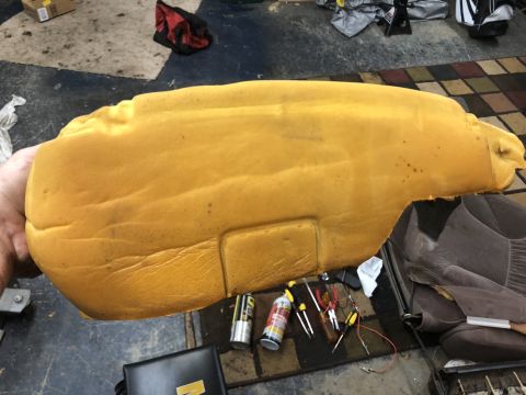 1995 Ford Bronco - A car seat foam cushion is shown, with tools and spray cans nearby on the floor.