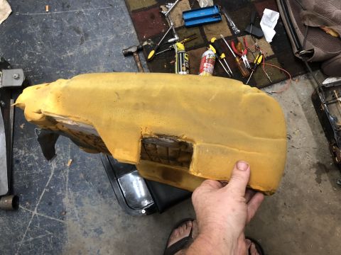 1995 Ford Bronco - A detached seat cushion is being held, revealing its internal foam structure and the underlying seat frame.