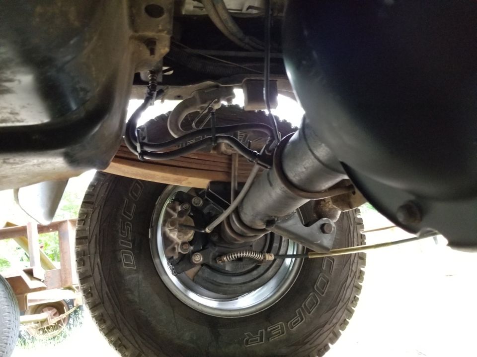 Underbody view of rear axle, leaf spring and Cooper tire on truck