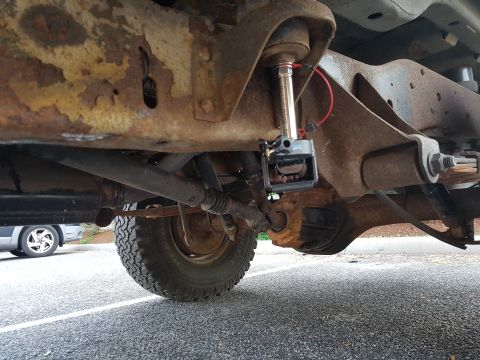 1978 Ford Bronco - A GoPro camera is mounted to the rusty suspension of an older vehicle, showing its undercarriage.