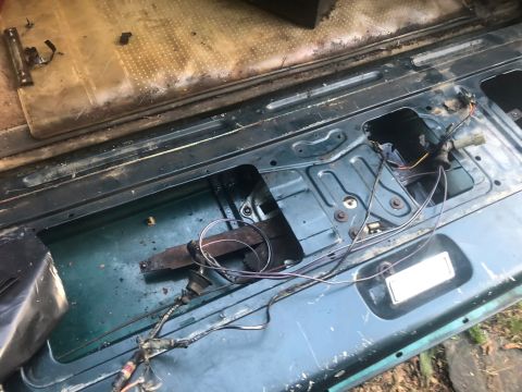 1995 Ford Bronco - Close-up of a vehicle's interior door mechanism, showing exposed wires and metal parts.