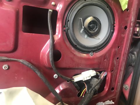 1994 Ford Bronco - Close-up of a car's interior door panel, showing a speaker and exposed wiring.