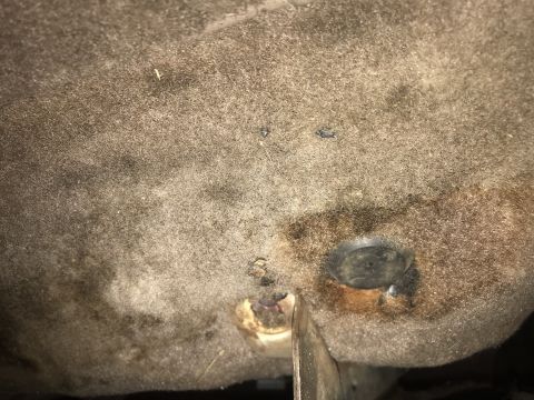 1994 Ford Bronco - Close-up view of the underside of a vehicle's carpet and frame, showing wear and tear.