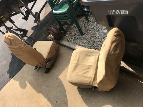 1994 Ford Bronco - Two tan car seats, possibly from a Ford Bronco, are shown outdoors with protective covers.