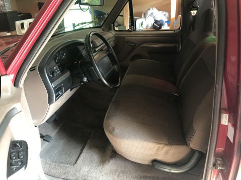 1994 Ford Bronco - The interior of a truck shows the passenger seat, dashboard, and steering wheel.