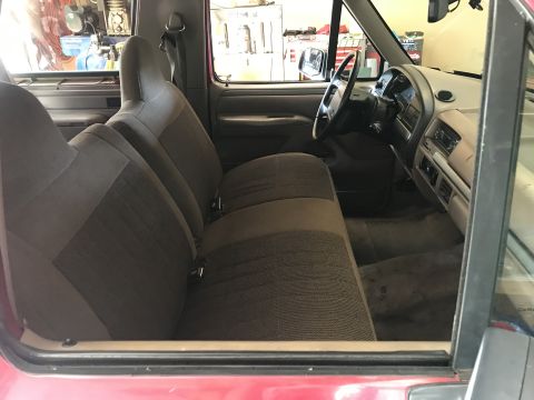 1994 Ford Bronco - Interior view of a red Ford truck, showing the front seats and dashboard.