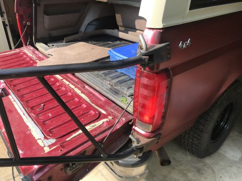 1994 Ford Bronco - Rear view of a red Ford Bronco, showing the tailgate and a 4x4 badge on the quarter panel.