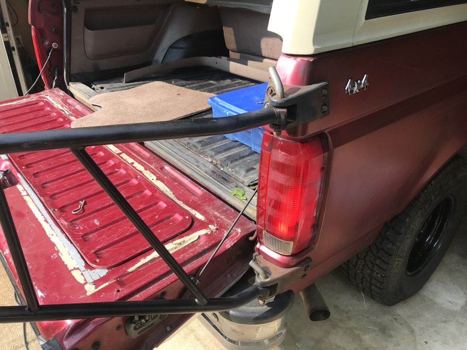 Red Ford Bronco rear quarter panel with 4x4 badge and open tailgate