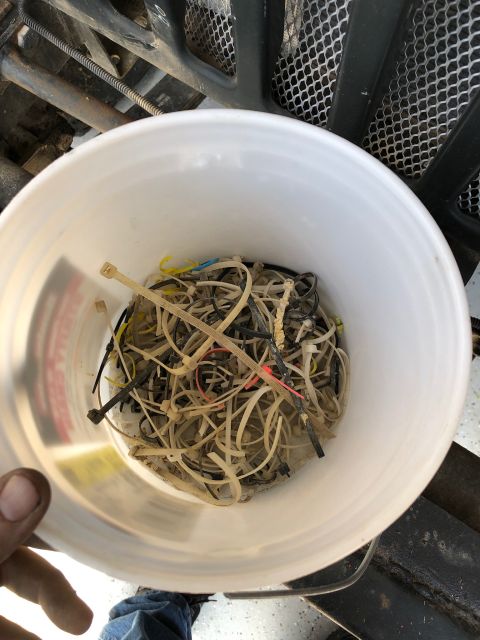 1992 Jeep Wrangler - Bucket overflowing with used zip ties and wire, likely from a vehicle tear-down project.