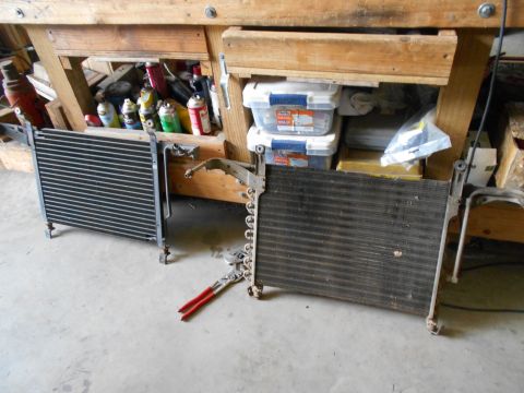 1992 Ford Bronco - Two automotive radiators or AC condensers are displayed on a concrete floor, with a pair of pliers nearby.