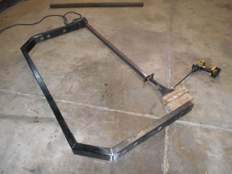 1992 Ford Bronco - A custom metal frame is shown on a concrete floor with a drill attached to a wooden support.