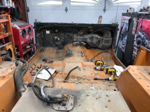 1992 Jeep Wrangler - The interior of a Jeep is shown completely stripped down, revealing the floor pan and dashboard components.