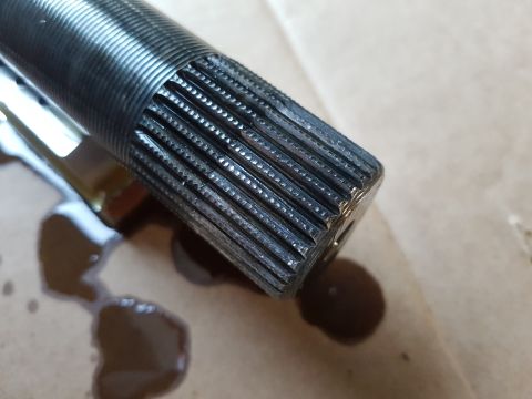 1978 Ford Bronco - Close-up of a splined shaft end, with dark oil drips visible on the surface below.