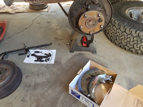 1978 Ford Bronco - New brake shoes and disassembled parts are laid out for a vehicle brake job.