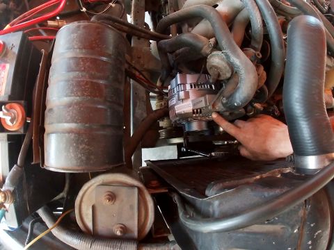 1978 Ford Bronco - A new alternator is shown installed in the engine compartment, with a hand pointing to it.