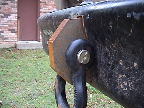 1978 Ford Bronco - Tight close-up of a black rear bumper end, showing a rusty steel gusset plate and a bolted-on D-ring shackle mount with a large bolt head.…