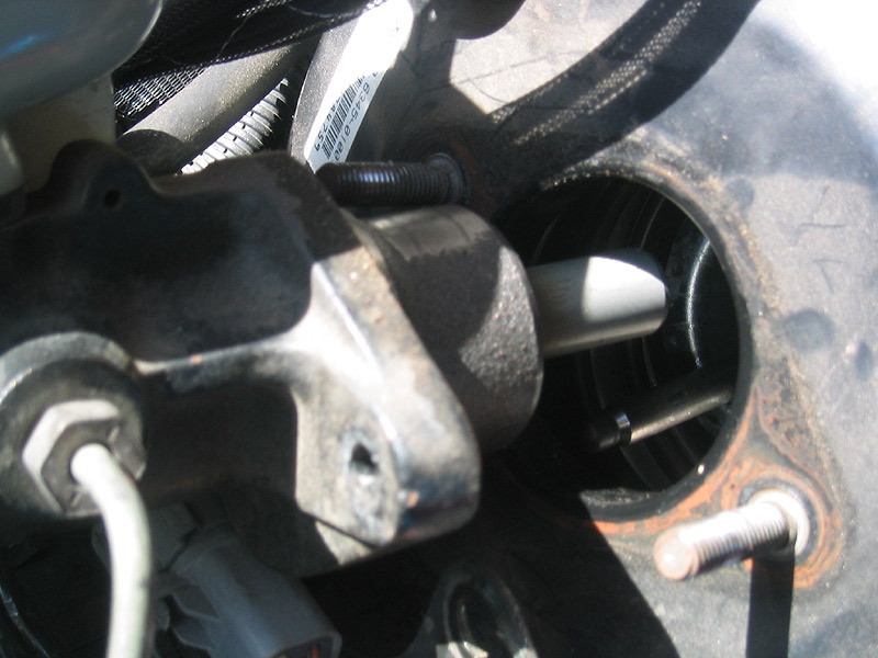 Close-up of brake master cylinder with visible part number label