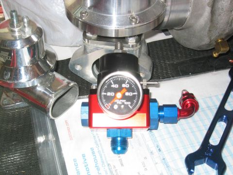 1992 Ford Crown Victoria - Automotive engine parts including a blow-off valve and fuel pressure regulator are laid out on a document.