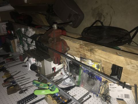 1994 Ford Bronco - A workbench is cluttered with various tools and equipment, including a vise, screwdrivers, and a fan.