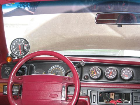 1992 Ford Crown Victoria - The interior of a 1992 Ford Crown Victoria shows a dashboard equipped with a tachometer, speedometer, and multiple auxiliary gauges.