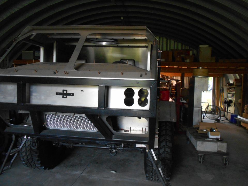 Custom vehicle frame with silver body, black bumper, and circular openings.