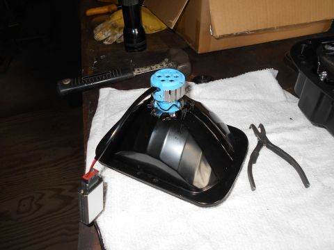 1992 Ford Bronco - A black headlight assembly with a blue LED bulb is placed on a white towel next to a pair of pliers and a wiring harness.