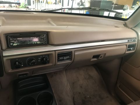 1994 Ford Bronco - The interior dashboard of a Ford Bronco shows a Pioneer stereo, climate controls with three knobs, and a "Power Point" outlet. A chrome tri…