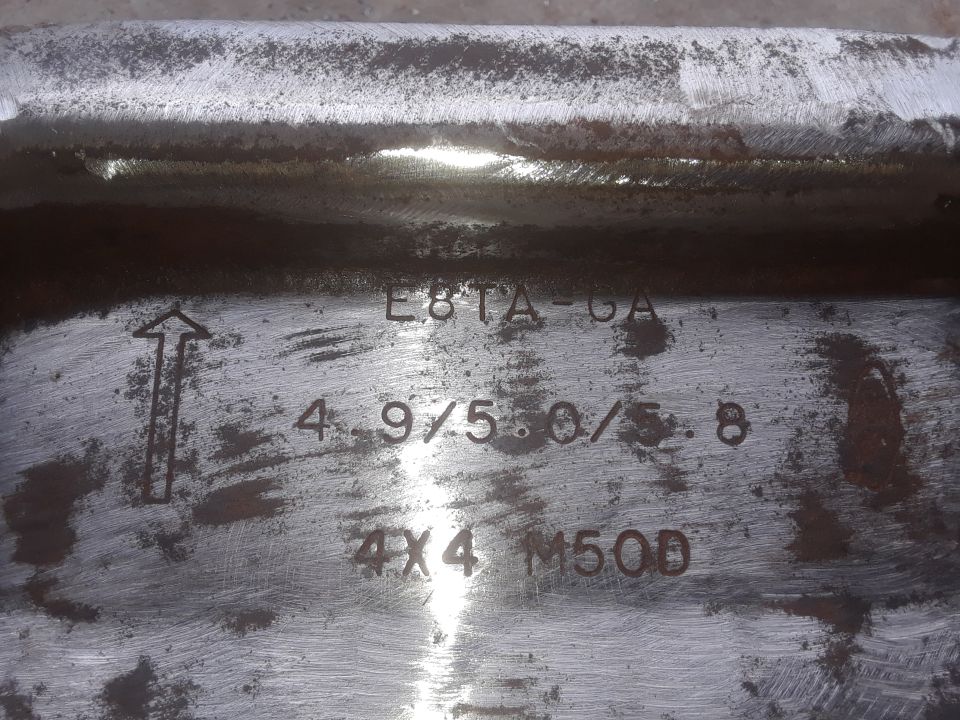 Metal part with stamped markings: arrow, E8TA-GA, 4.9/5.0/5.8, 4X4 M50D