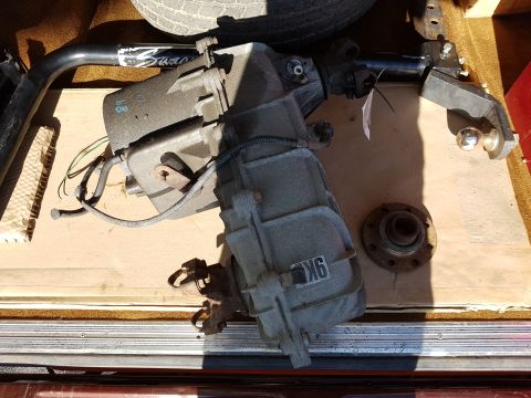 1978 Ford Bronco - A transfer case and a trailer hitch receiver are shown in a vehicle's cargo area, resting on cardboard.