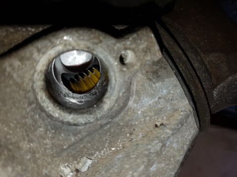 1978 Ford Bronco - A close-up view inside a metal housing shows a yellow gear with a dark, reflective surface above it. The surrounding metal appears aged and…