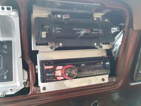 1978 Ford Bronco - The interior of a vehicle shows a JVC car stereo installed below the climate controls. A portion of the instrument cluster is visible to th…