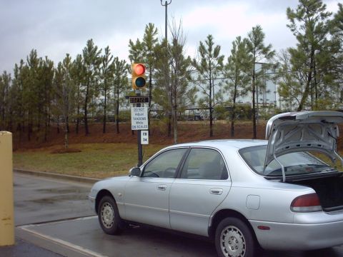 1995 Mazda 626 - Silver 1995 Mazda 626 sedan with its trunk open, positioned near a traffic light and industrial scales.