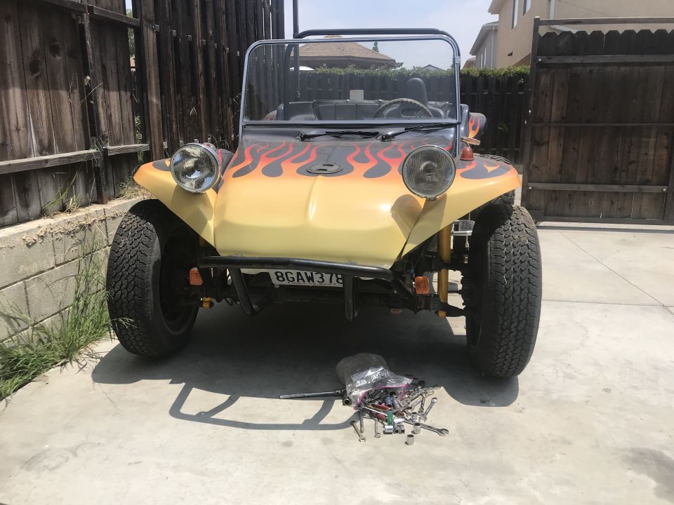 Cream dune buggy with flame paint, front view, tools scattered on driveway in front
