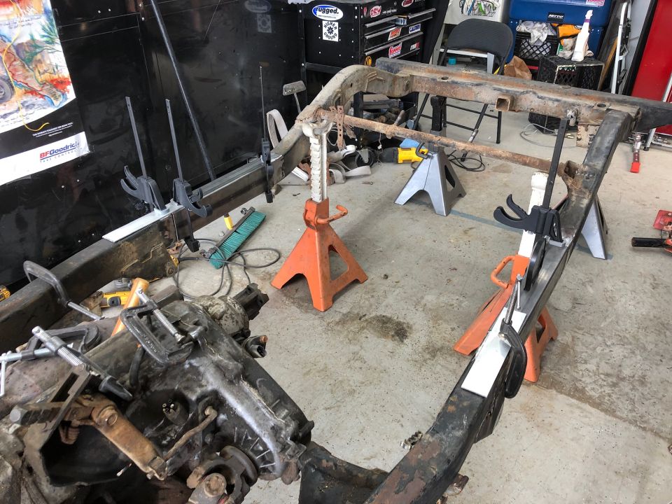 Jeep Wrangler frame on jack stands with metal plates clamped on.