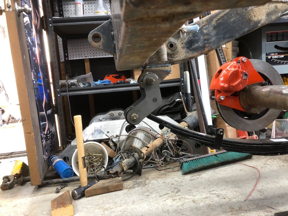 Vehicle frame and leaf spring suspension on jack stands in garage