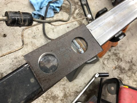 1992 Jeep Wrangler - A close-up view shows a metal plate with two circular cutouts welded onto a metal beam. One cutout reveals a fresh weld, suggesting recent…
