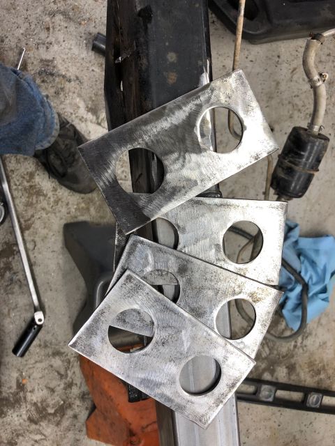 1992 Jeep Wrangler - A stack of four metal plates, each with two circular cutouts, are resting on a metal beam. The plates appear to be part of a custom fabrica…