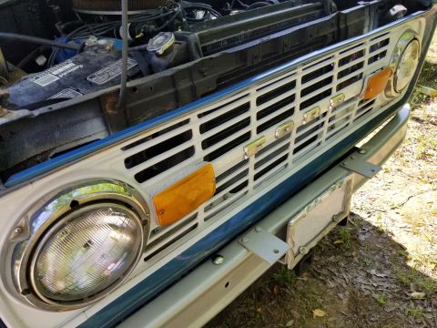 1974 Ford Bronco - The battery is being kept away from shorting against the body by a 2x4; the Right headlight is loose in its bucket; the bumper is bent & mi…
