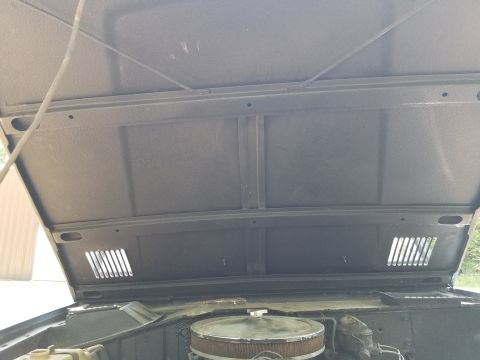 1974 Ford Bronco - The hood looks OK, but the bedliner goes out to the surface of the paint on the vent louvers. The prop rod is mangled.