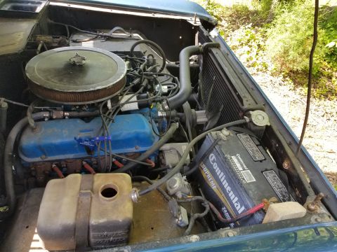 1974 Ford Bronco - The battery is being kept away from shorting against the body by a 2x4; the coolant overflow hose is split & loose; the PS was very low. [u…